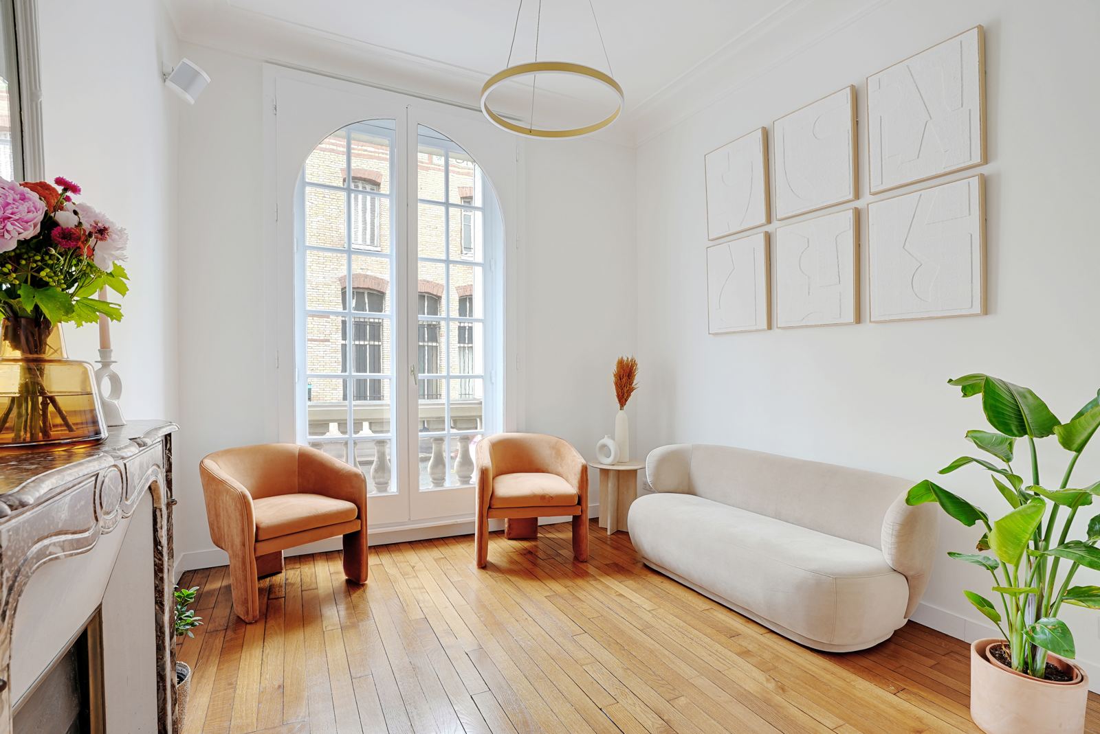 Salle d'attente lumineuse avec fauteuils, canapé et cheminée en marbre